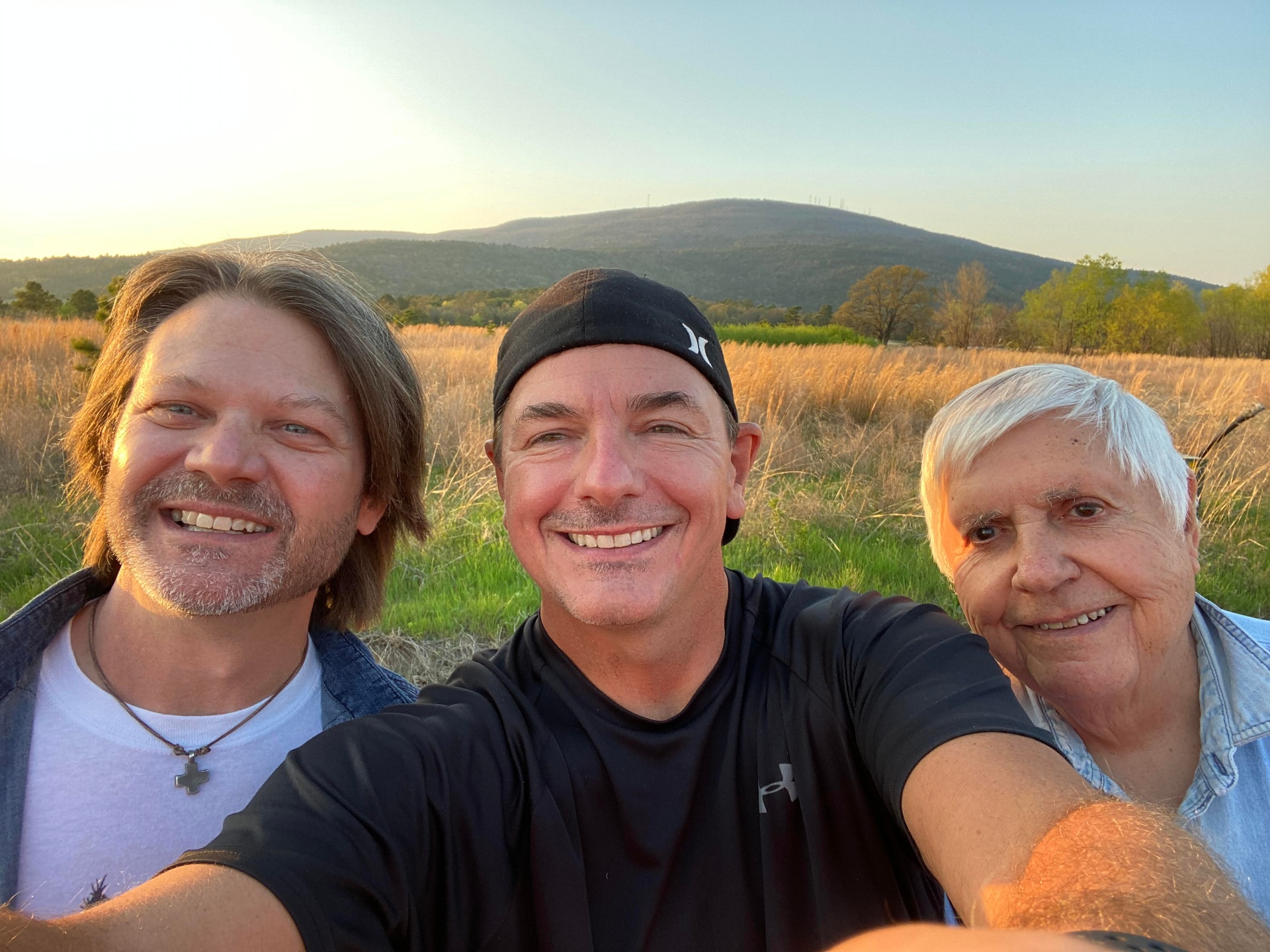 David Carbrey, Bryan Warren, and Bryan's father Dean Warren in a field at sunset, Oklahoma, 2021